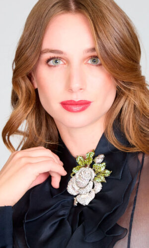 Blusa de gasa negra con vuelos y detalle floral. Falda larga, de encaje de lentejuelas con abertura central.