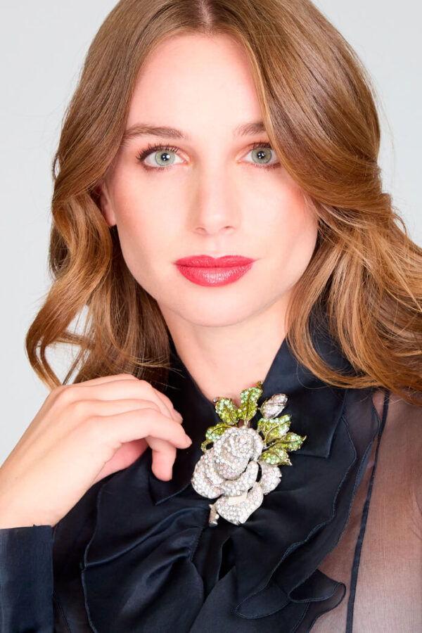 Blusa de gasa negra con vuelos y detalle floral. Falda larga, de encaje de lentejuelas con abertura central.