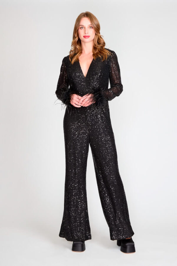 Enterito negro de lentejuelas con escote pronunciado y mangas largas con detalles de plumas.