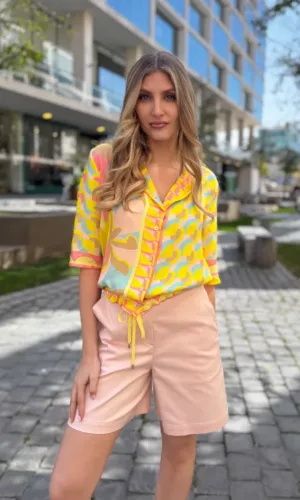 Blusa ligera en tonos amarillo y rosa con estampado geométrico, combinada con short rosa de tiro medio - Carola Pino Boutique