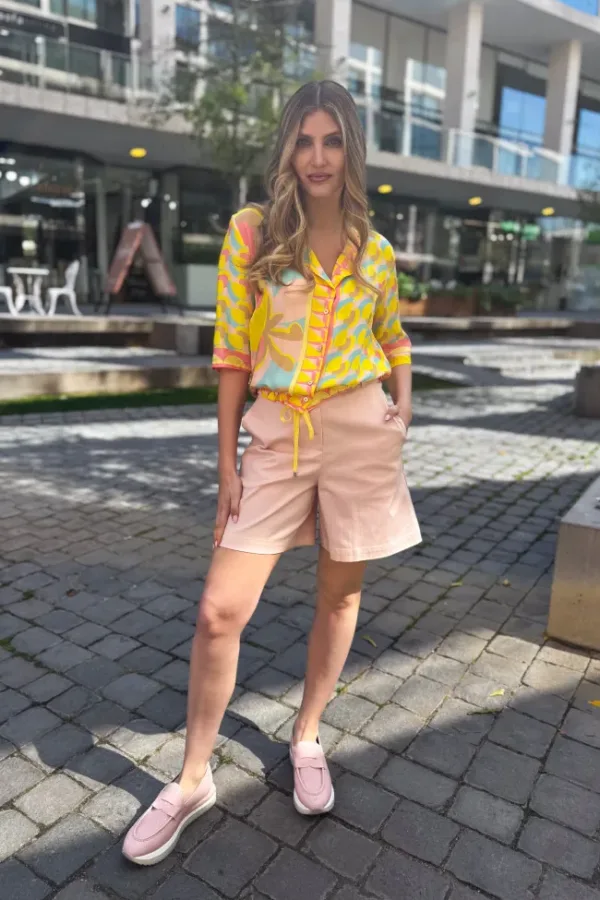 Blusa ligera en tonos amarillo y rosa con estampado geométrico, combinada con short rosa de tiro medio - Carola Pino Boutique